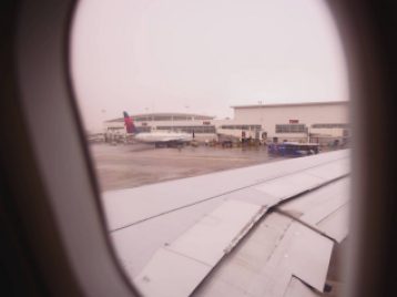 Shot through the window of a plane of the wing, and other planes, and DTW airport